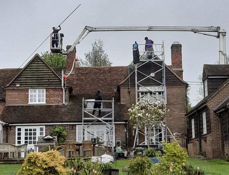 The Moss Cleaners using cherry picker and scaffolding to clean roof safely and professionally in Bordon, Hampshire